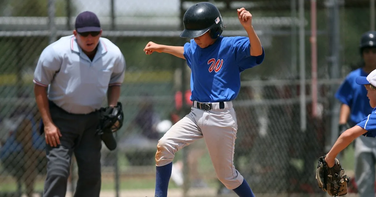 a youth baseball player crossing home plate and scoring a run