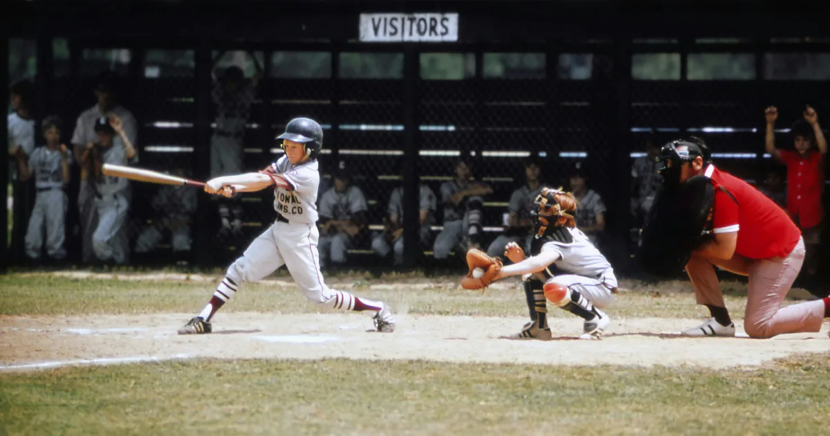 A youth baseball player swinging a bat during a game
