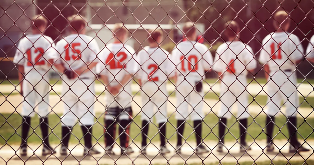 a youth baseball team on the sideline before a game