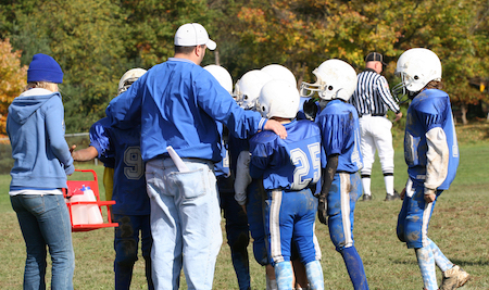 a youth football coach with his team