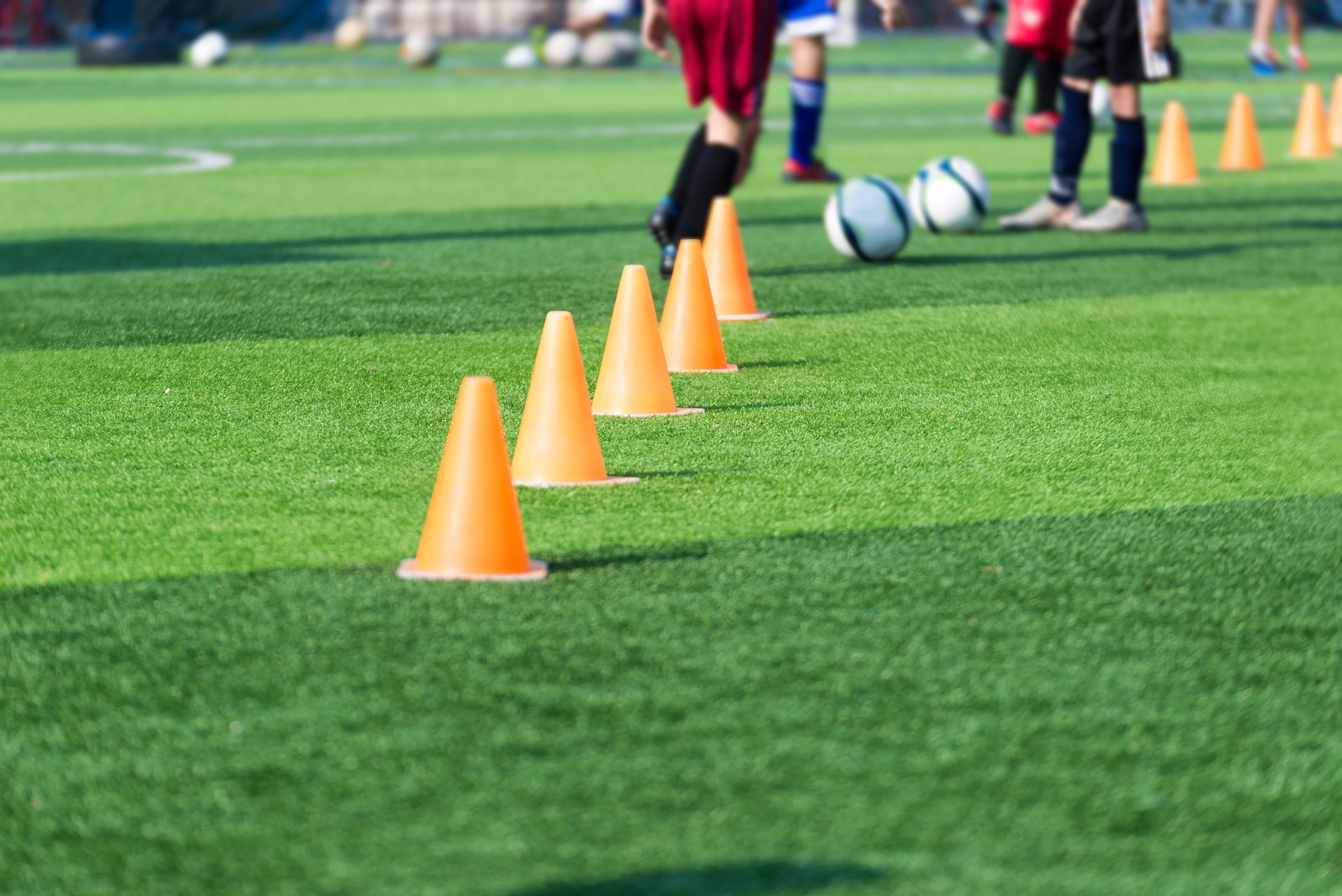 a youth soccer team running dribbling drills