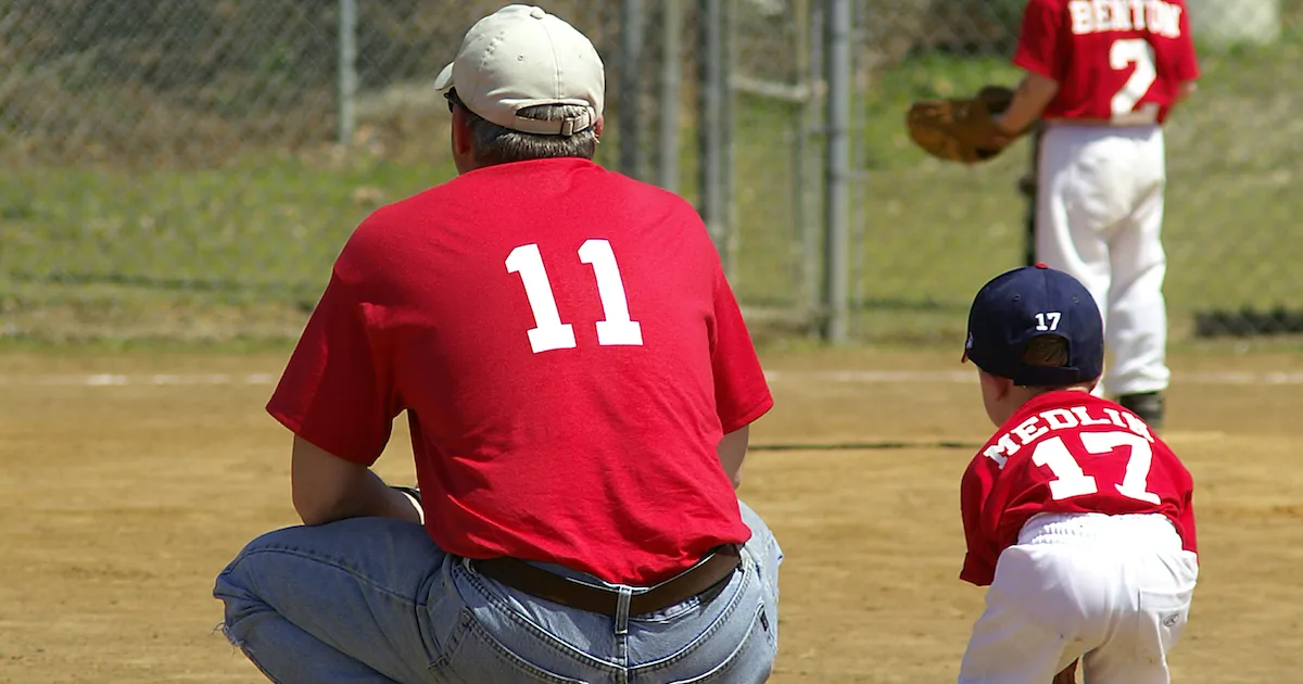 a coach with a youth baseball player