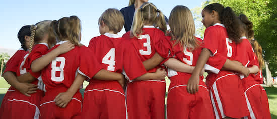 a group of youth soccer players huddling before a game
