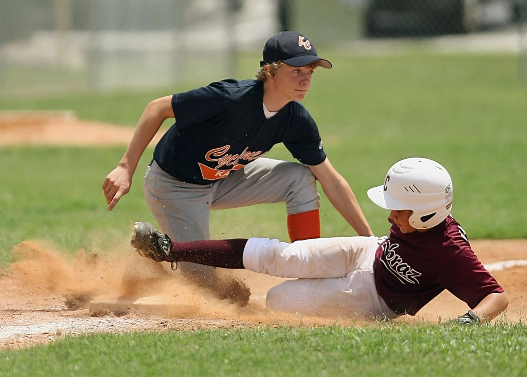 a youth baseball player sliding into third base