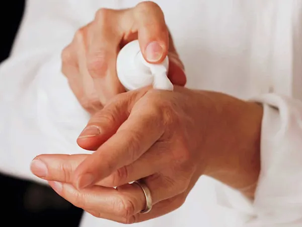 Woman putting cosmetics on her hand