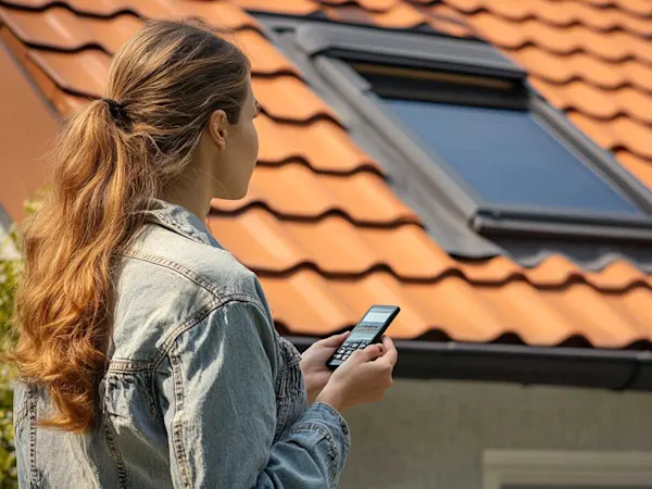 Woman using remote on electric pvc windows