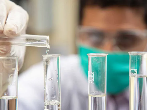 Scientist in lab pouring test tube