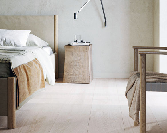 Stilrent soverom i lyst tre, hvit seng med okergult pledd, trebord og vegglampe.