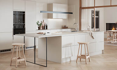 Lyst, minimalistisk kjøkken med hvit kjøkkenøy, trekrakker, eikeparkett og peis.