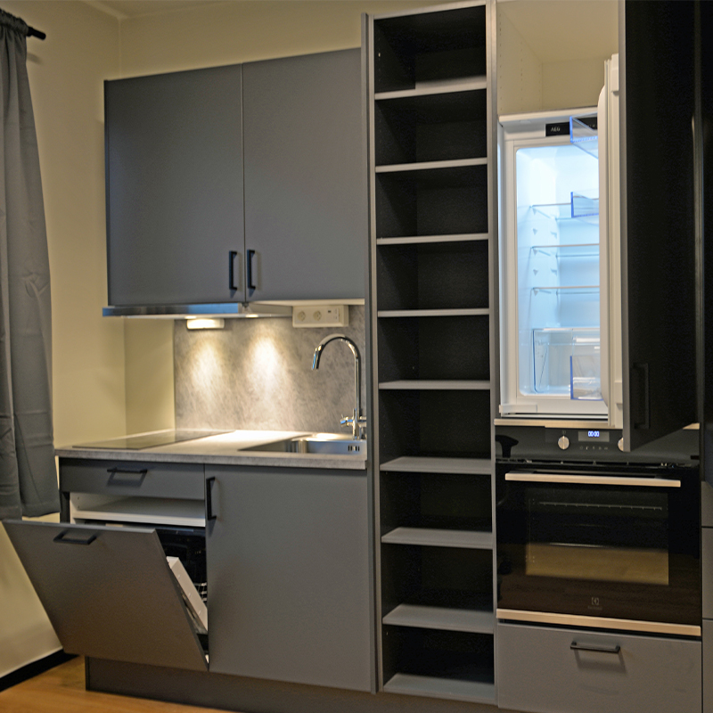 Grått minimalistkjøkken med åpnet kjøleskap, åpen oppvaskmaskin, vask og tomme hyller.