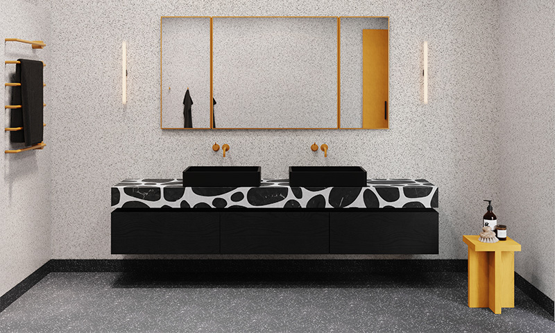 Moderne bad med svart-hvitt terrazzo-benk, to svarte servanter, gullspeil og gul krakk