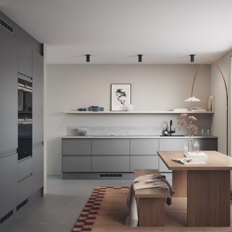 Minimalistisk kjøkken med gråe skuffer, tremøbler, buelampe og tørkede blomster