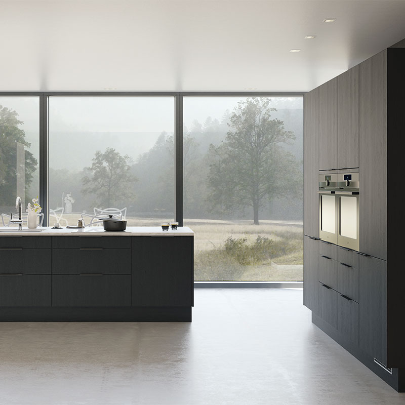 Moderne kjøkken med mørkegrå skap, hvit øy og store vinduer mot tåkete skoglandskap.