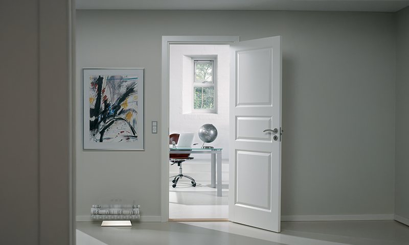 Hvit innerdør inn til kontor på lys vegg
