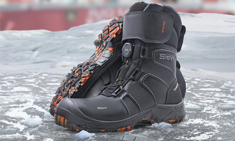 Svart Sievi-vinterstøvel med oransje sålemønster og Gore-Tex-logo på isete underlag.