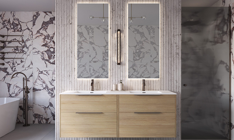 Lyst baderom med dobbel treskapvask, bakbelyste speil, marmormønstrede vegger og frittstående badekar