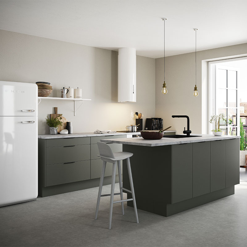 Lyst kjøkken med grønn øy, hvitt SMEG-kjøleskap, hengende lyspærer og svart kjøkkenkran.