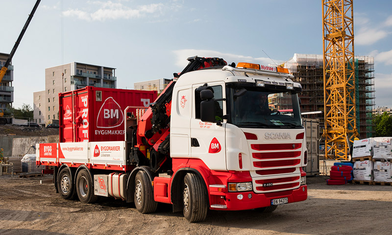 lastebil med container fra byggmakker