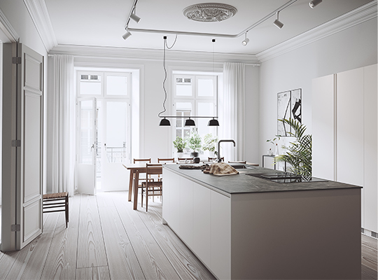 Lyst skandinavisk kjøkken med grå øy, trebord, svarte pendel­lamper og grønne planter.