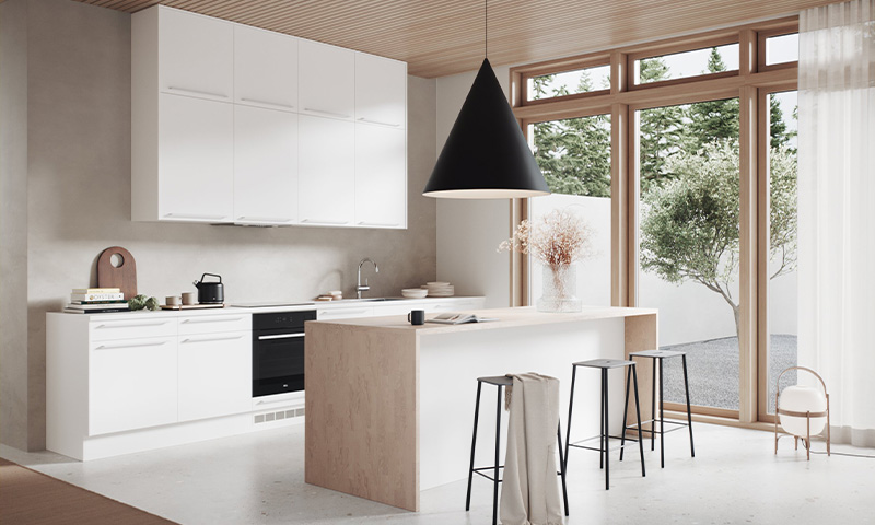 Lyst, moderne kjøkken med hvite skap, lys trefiner øy, svart pendellampe og store vinduer mot trær