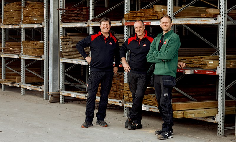 tre menn som står ved terrassebord på reoler