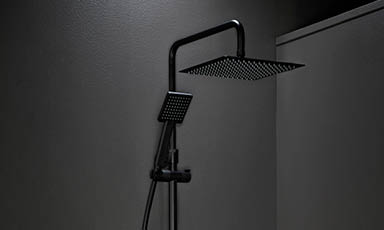 Minimalistisk sort kvadratisk regndusj med hånddusj mot mørk grå vegg