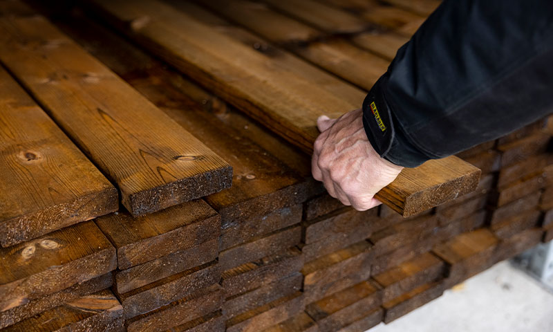 ansatt i trelasten velger terrassebord for kunde