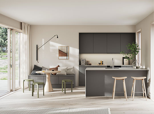 Lyst moderne kjøkken‐stue i beige og grått med kjøkkenøy, barkrakker og store vinduer.