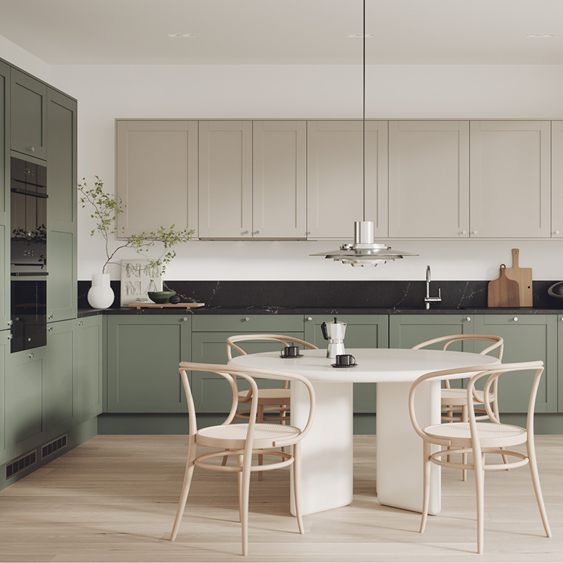 Moderne kjøkken med grønne og kremfargede skap, svart benkeplate og bord med fire lyse stoler.