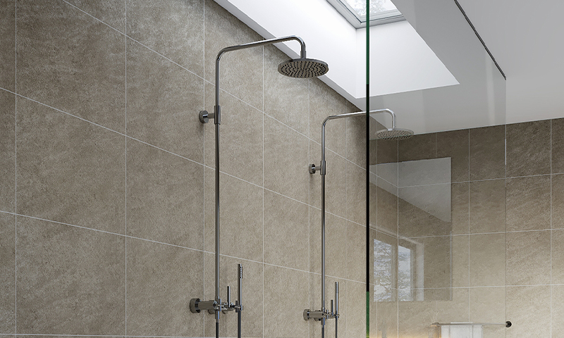 Moderne dusj med beige fliser, glassvegg og to krom regndusjhoder under takvindu