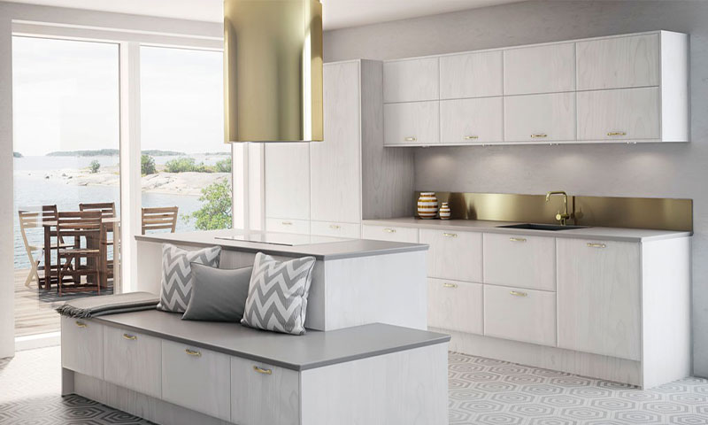 Lyst, skandinavisk kjøkken med hvite skap, grå benkeplate, messingdetaljer og sjøutsikt