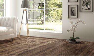 Lyst stuehjørne med mørkt tregulv, hvit sofa, tripod-lampe, orkidé og store vinduer mot hage