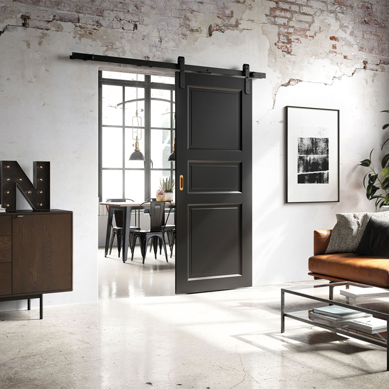 Moderne rom med svart skyvedør til spisestue, hvit murvegg, brunt skinnsofa og glassbord.