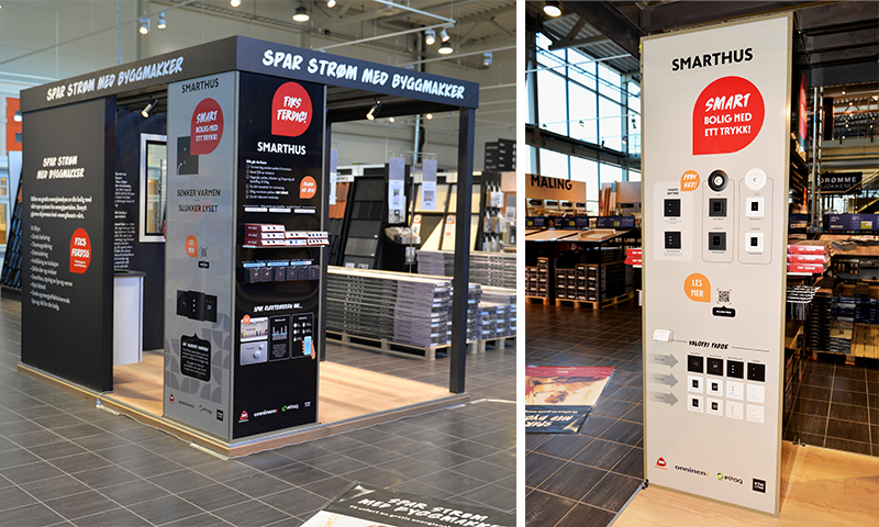 Svart Smarthus-stand med røde detaljer og hvite «Spar strøm med Byggmakker»-skilt i butikk