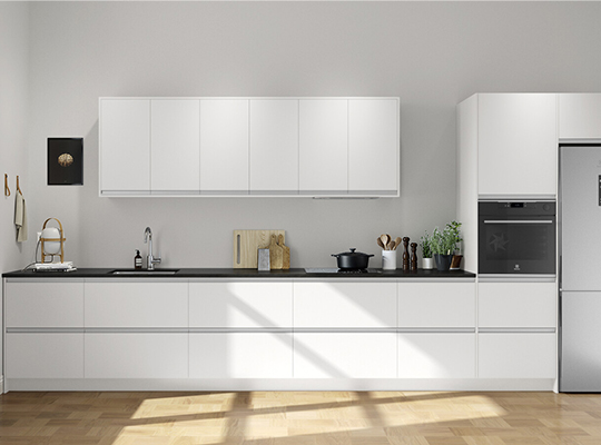 Lyst, moderne hvitt kjøkken med svarte benkeplate, kokekar, treredskaper og grønn plante