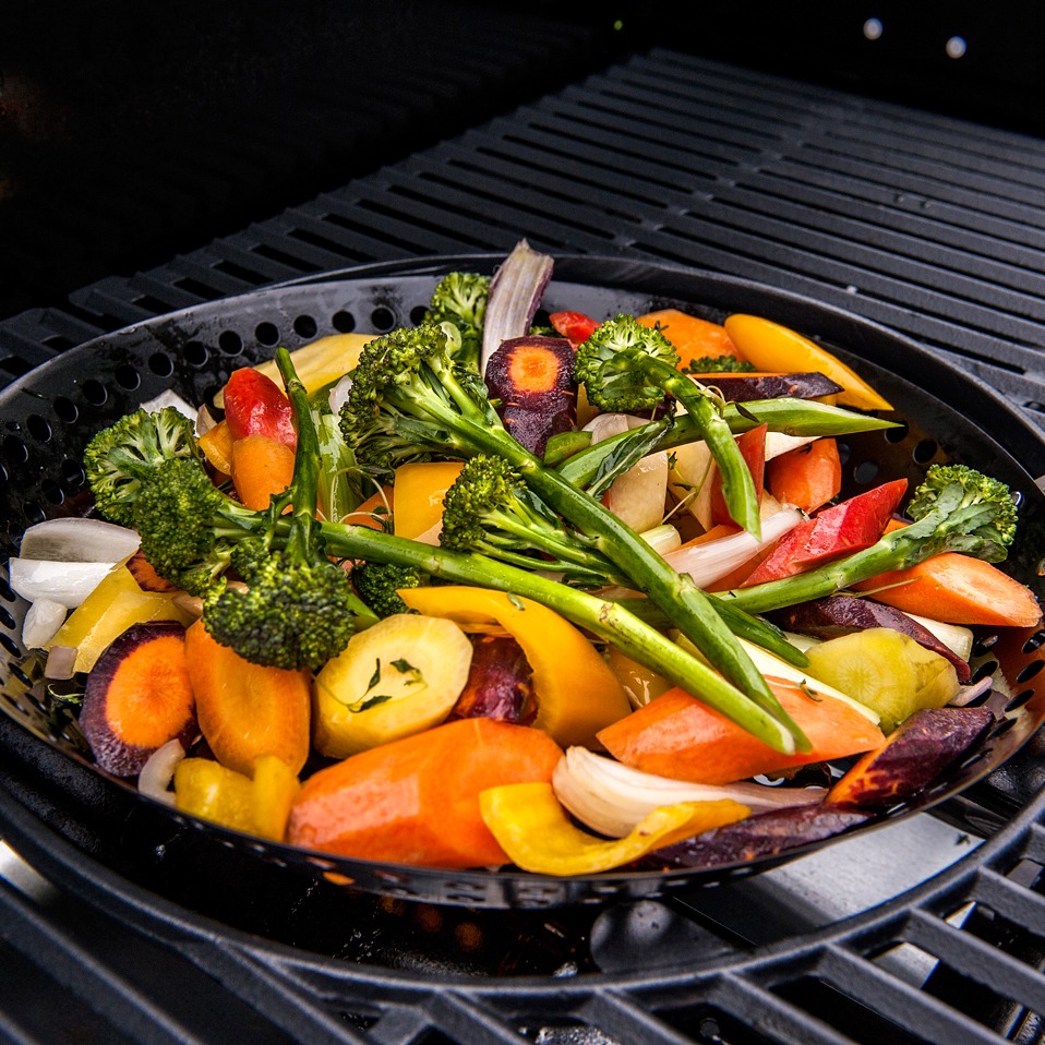 En grillkurv med brokkoli, gul og rød paprika, oransje og lilla gulrøtter, asparges og løk.