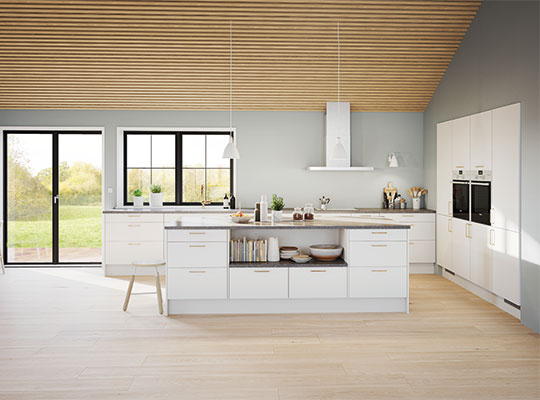 Lyst, moderne kjøkken med hvite skap, kjøkkenøy, trelistet tak og store vinduer mot hage.