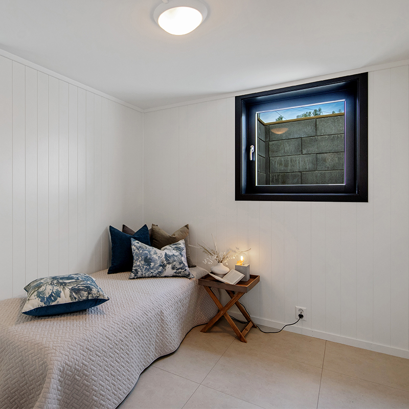 Soverom i kjeller med innadslående vindu