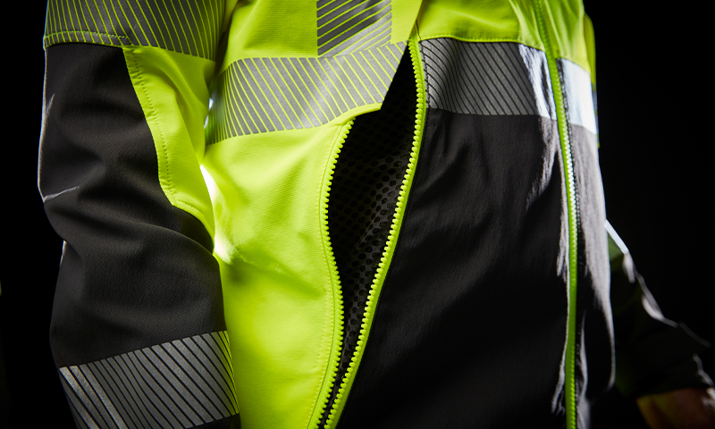 Nærbilde av gul-svart refleksjakke med åpen glidelås og reflekser