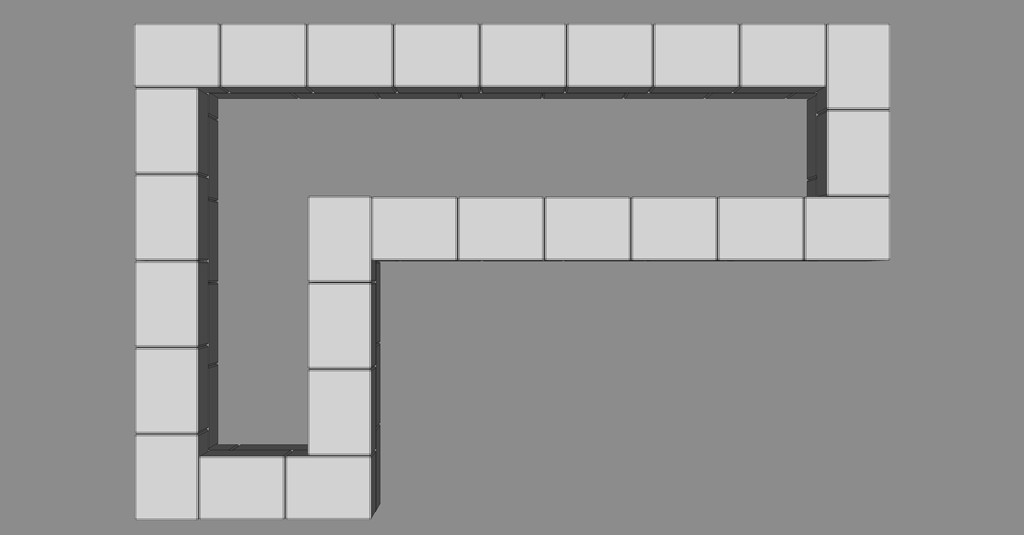 Ovenfra: L-formet modul av lysegrå rektangulære blokker på grå bakgrunn.