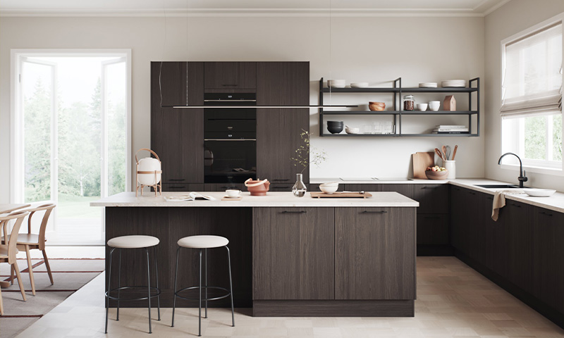 Lyst kjøkken med mørke trefronter, hvit kjøkkenøy med to hvite barkrakker og åpne hyller.