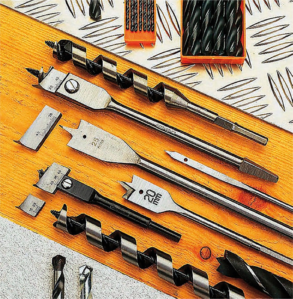 Ulike ståldrillbor, flatebor og spiralbor på treplate og metallplate, med oransje bokser.