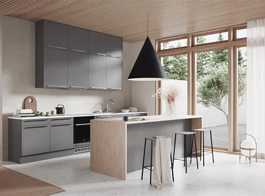 Moderne kjøkken med grå skap, lys tre-øy, svart pendellampe og vinduer til hage.