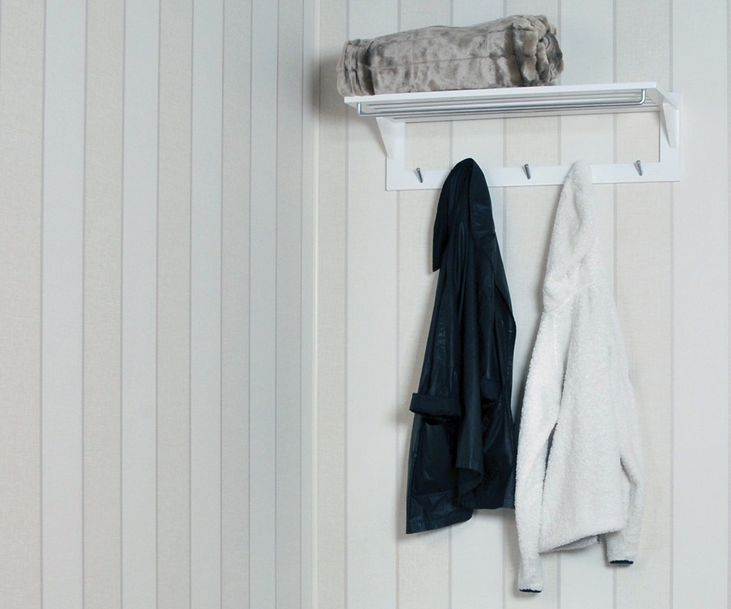 Hvit vegghylle med beige pledd og to jakker (mørkeblå, hvit) hengende på kroker.
