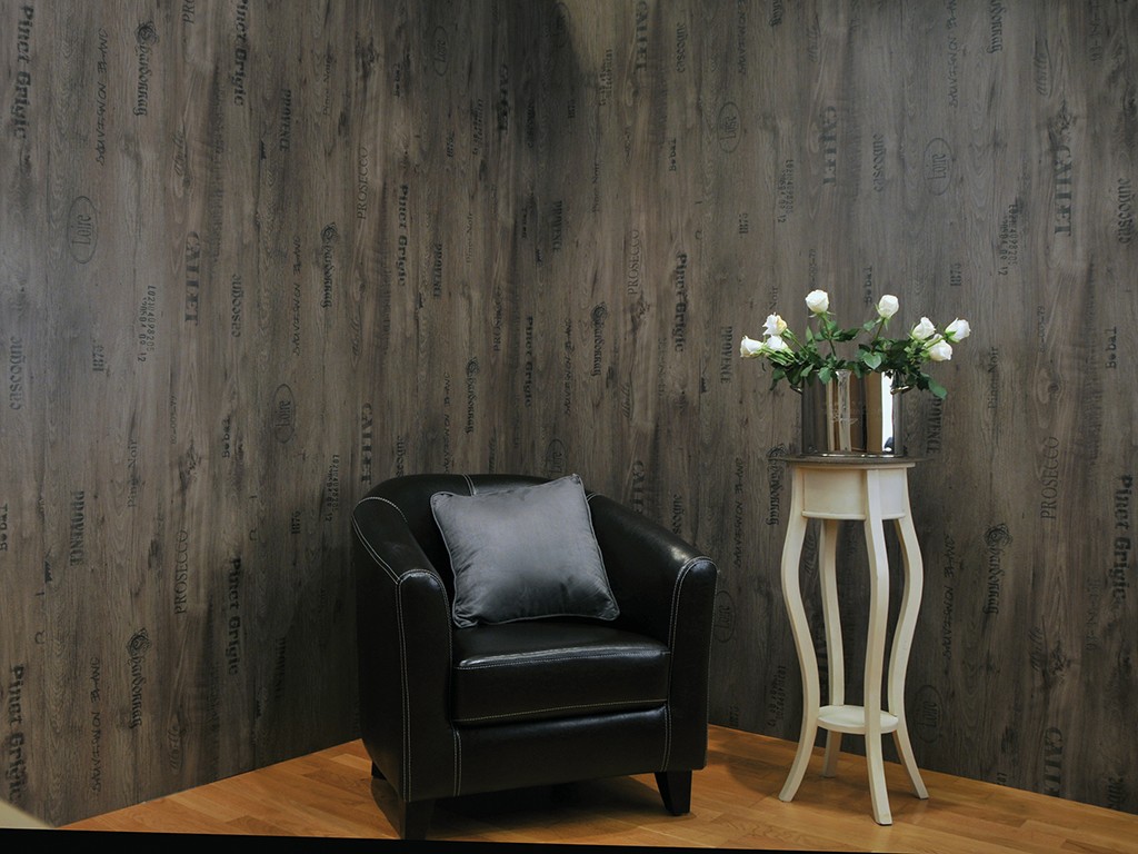 Interiørhjørne: mørk trefinérvegg, svart skinnstol med grå pute, hvitt sidebord med hvite roser