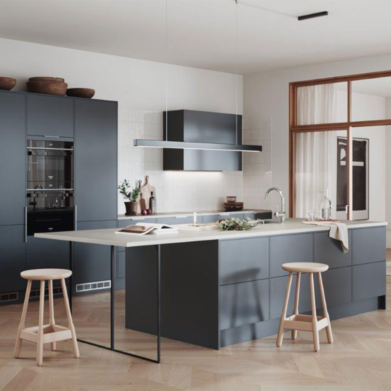 Moderne kjøkken med grå skap, lys benkeplate, kjøkkenøy, to lyse treskamler og vindu.