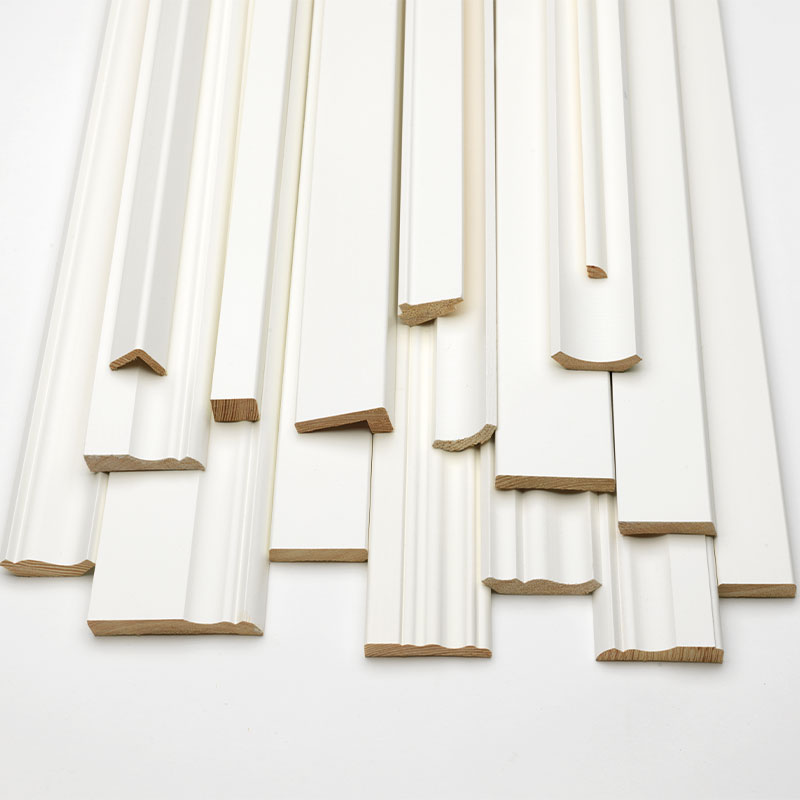 Hvitmalte trelister med ulike dekorprofiler liggende på lys bakgrunn.