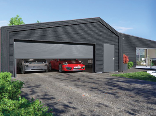 Svart garasje med delvis åpen port, sølv- og rød bil inni, hus og hage bak.