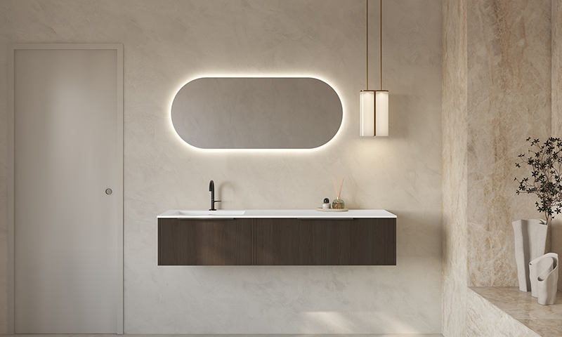 Minimalistisk baderom med mørkt treunderskap, hvit benkeplate, opplyst oval speil og hengelampe.