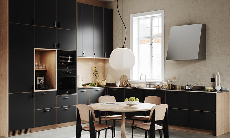 Moderne kjøkken med svarte skap, eikeinnslag, rundt trebord med fire stoler, hengelampe.